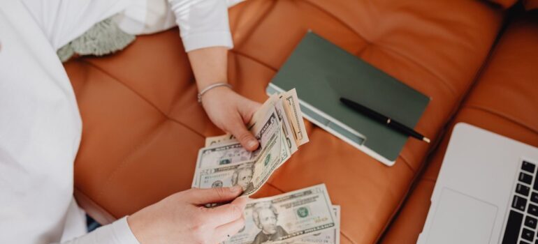 A woman counting money after learning about avoiding hidden moving costs