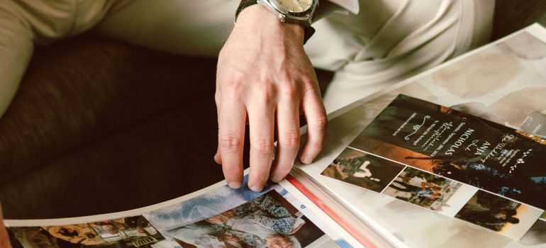 A person looking through an album and thinking what to do with a lifetime of photos and documents before a move