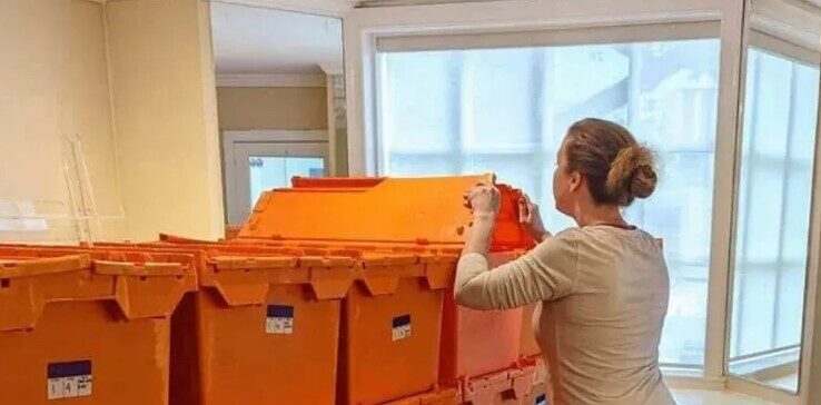 A woman looking at plastic crates