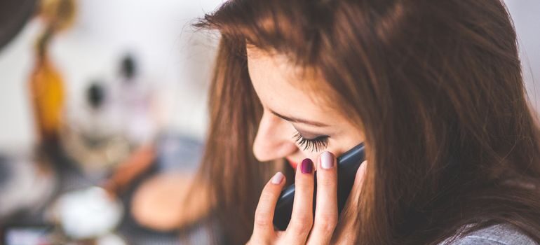 A woman talking on the phone before moving from San Francisco to Walnut Creek.
