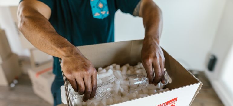A man packing fragile glasses