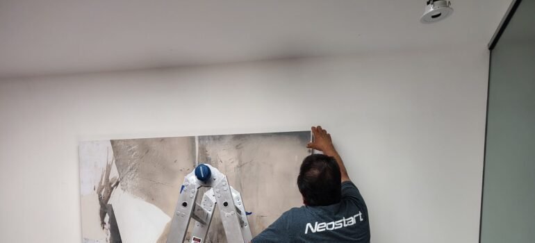 A man hanging a photo
