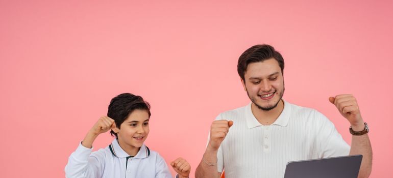 A man and a child studying and cheering