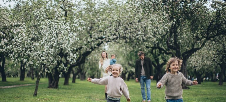 Children and parents running in a park.