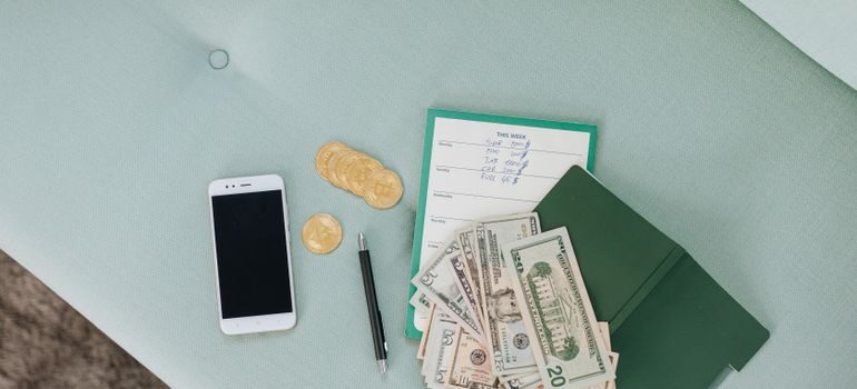 A list, coins, bills, and a phone on the table after moving near BART