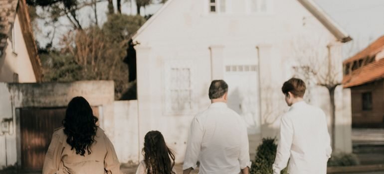 Family with children walking together through a new neighborhood during the first weeks after moving