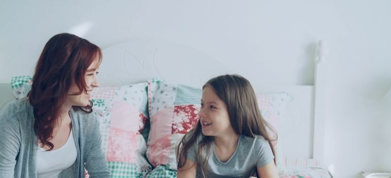 Parent having a serious conversation with a young child at home about an upcoming family change