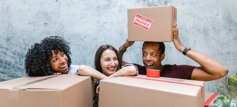 man and two women standing among boxes